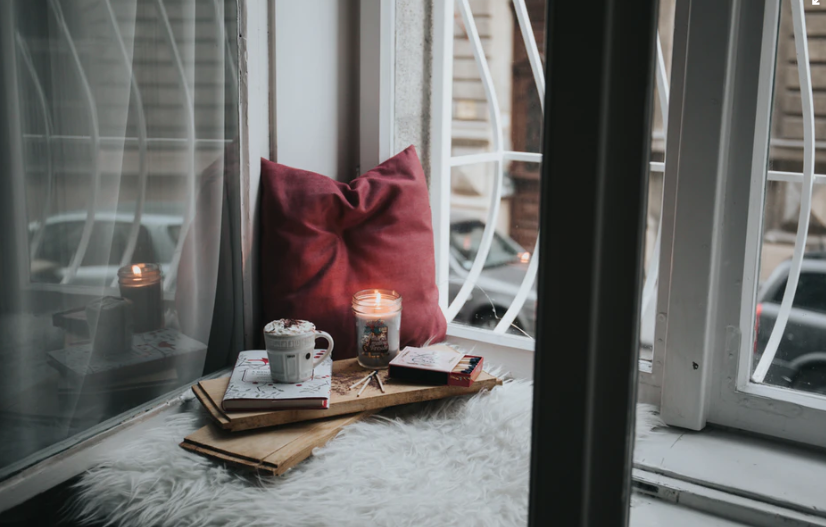Image of relaxing corner of a room with a candle ,book and cup of tea