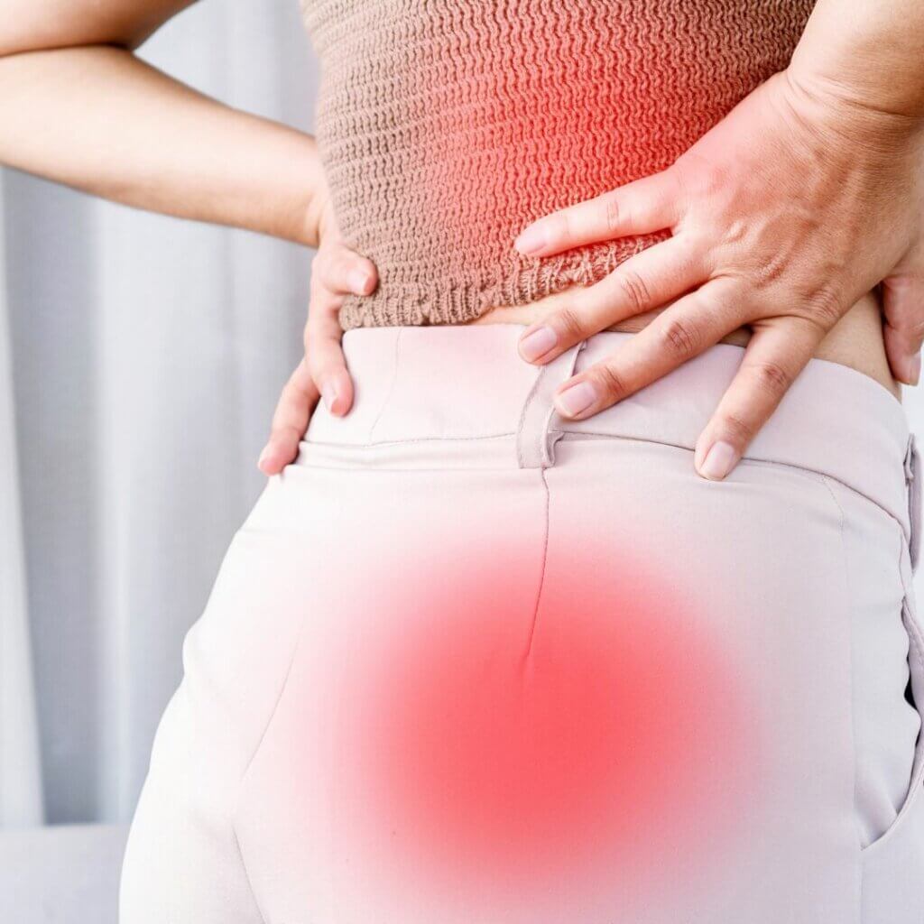photo of woman grabbing her low back because of sciatica pain
