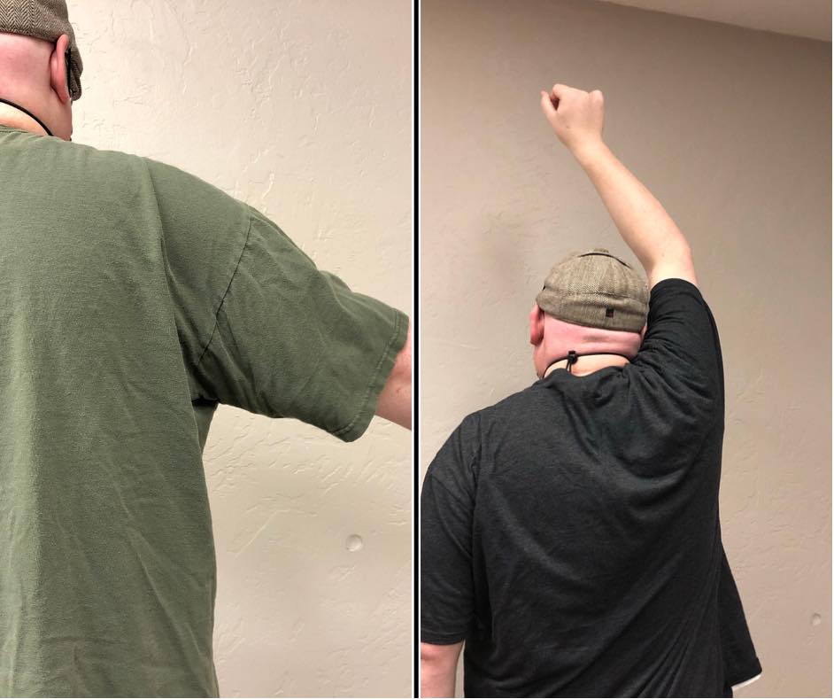 Photo of cupping therapy client facing a wall with his arm extended above his head showing an increase of range of motion.